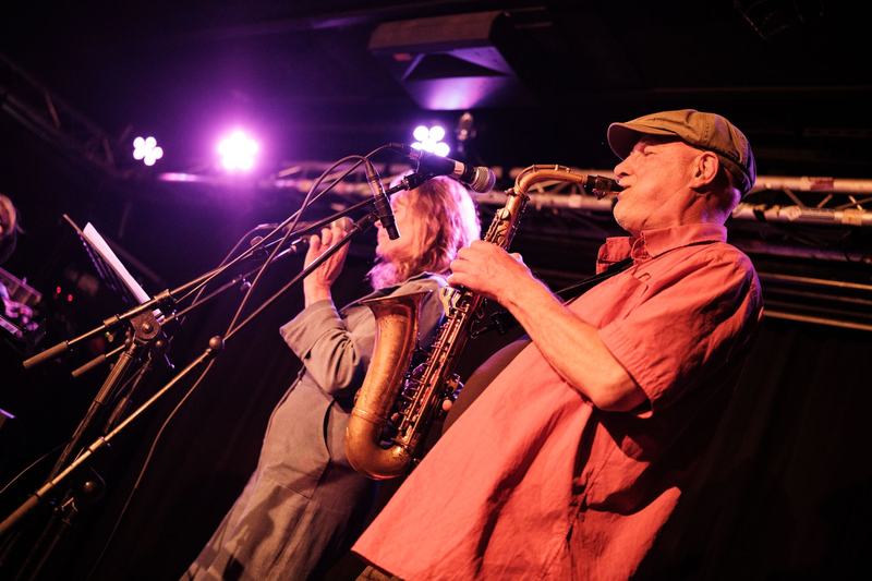 Saxofonist en vocalist van Love Is A Ride in paars licht