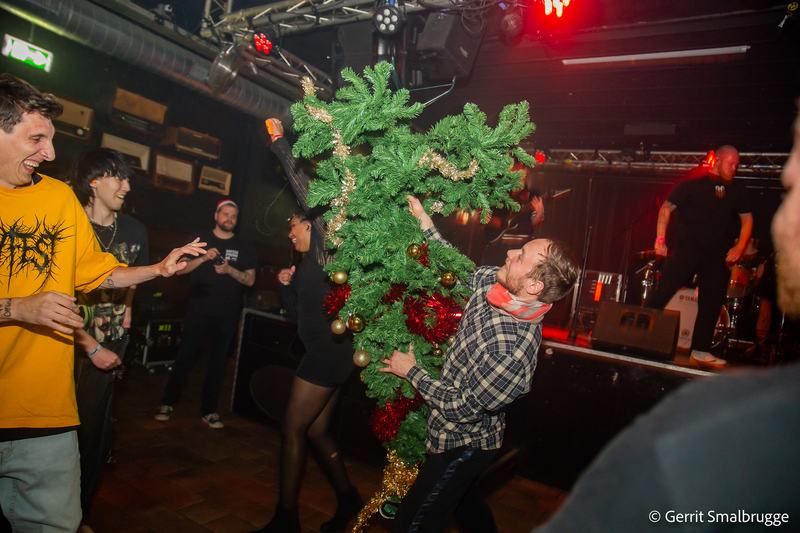 Iemand in de pit met een kerstboom in de armen